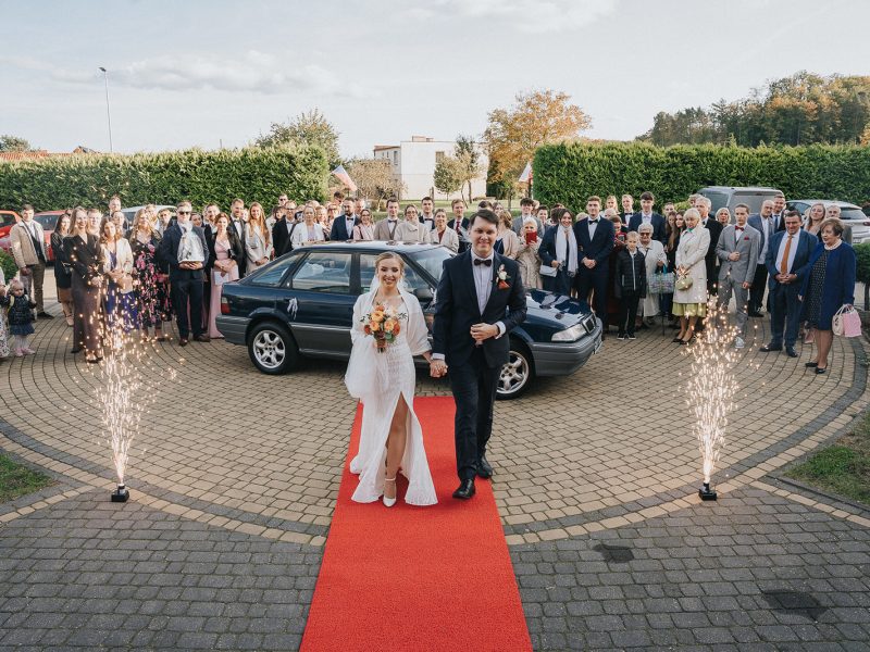 Fontanna iskier podczas powitania pary młodej na czerwonym dywanie przed wejściem